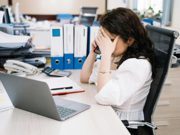 Femme tenant sa tête en surcharge mentale burnout au travail