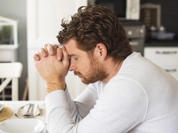 Homme fatigué qui a la tête dans ses mains